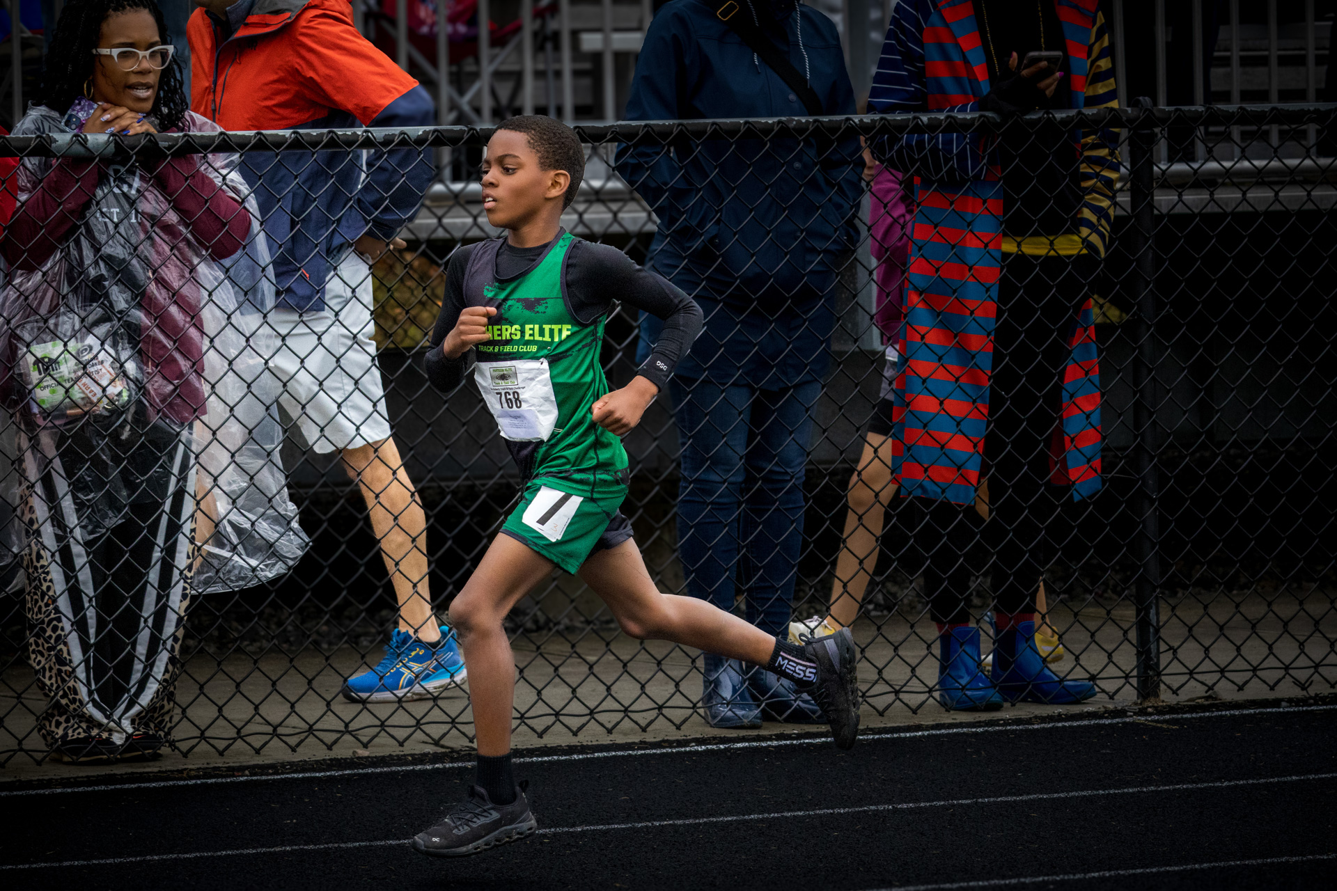 Young athlete running on track during a Panthers Elite meet.