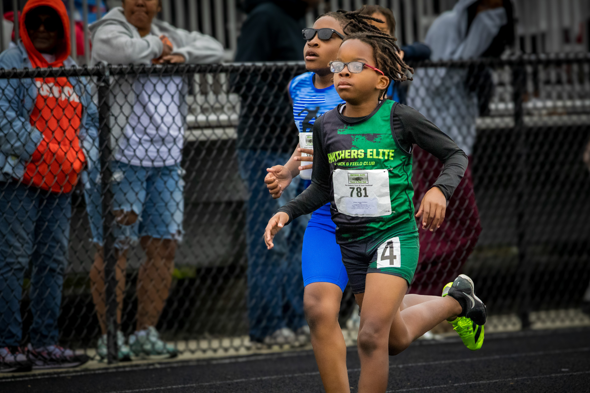 Young female athlete running on track during a Panthers Elite meet.
