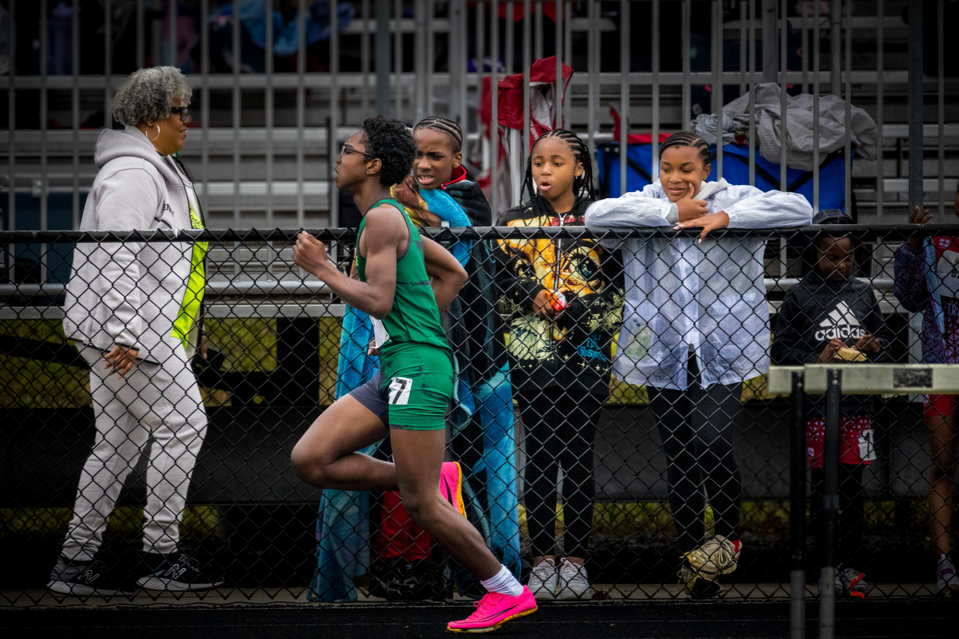 Young female athlete talking to coach during track meet.
