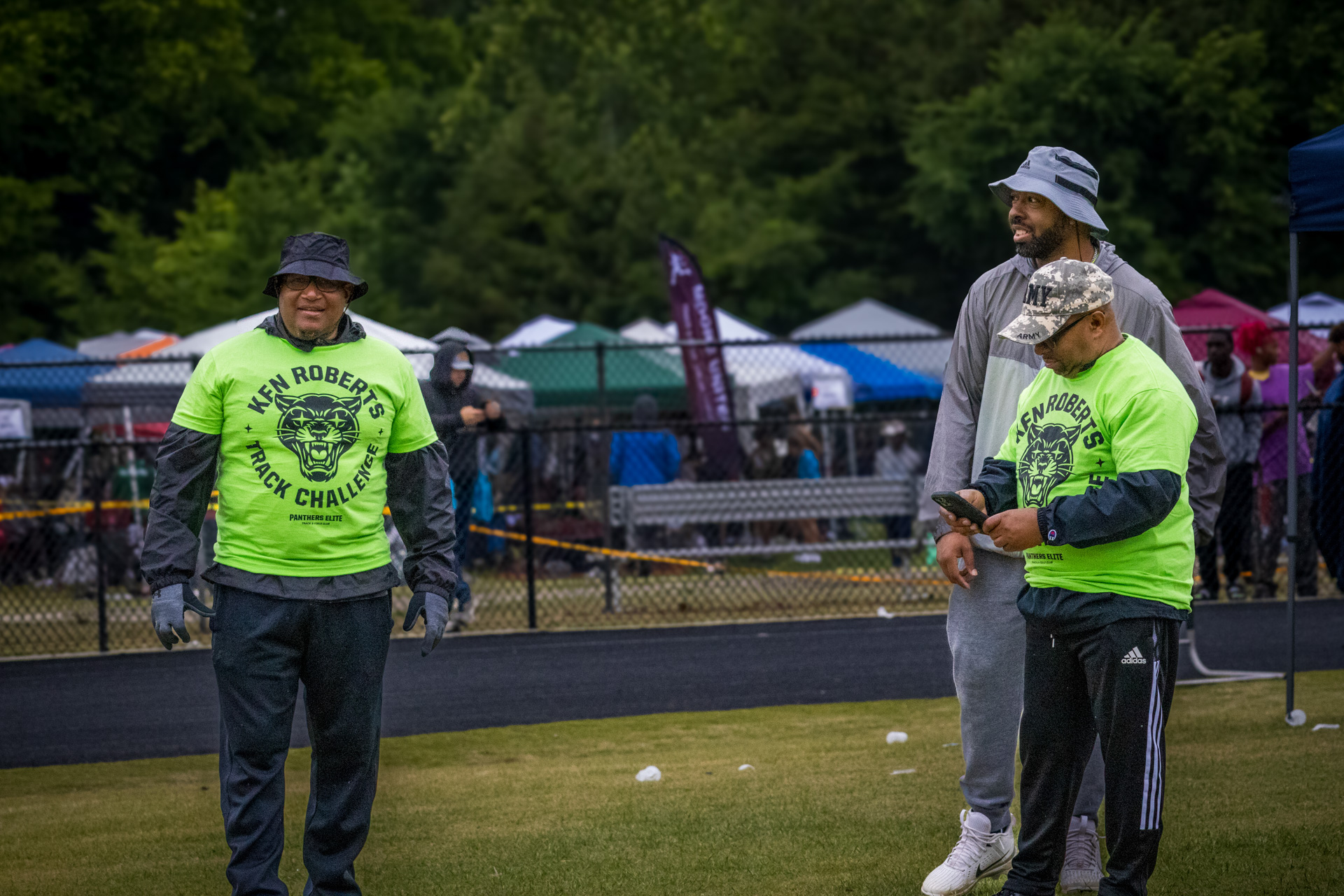 Panthers Elite Track & Field coaches standing on the field during a meet.