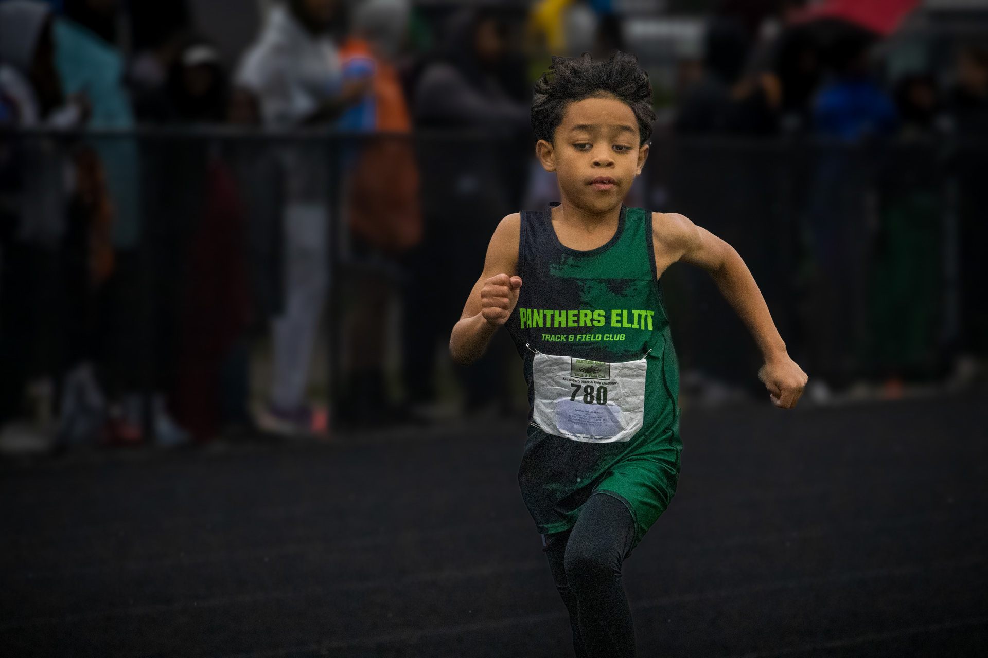 Young athlete running in Panthers Elite Track & Field Club uniform during a race.