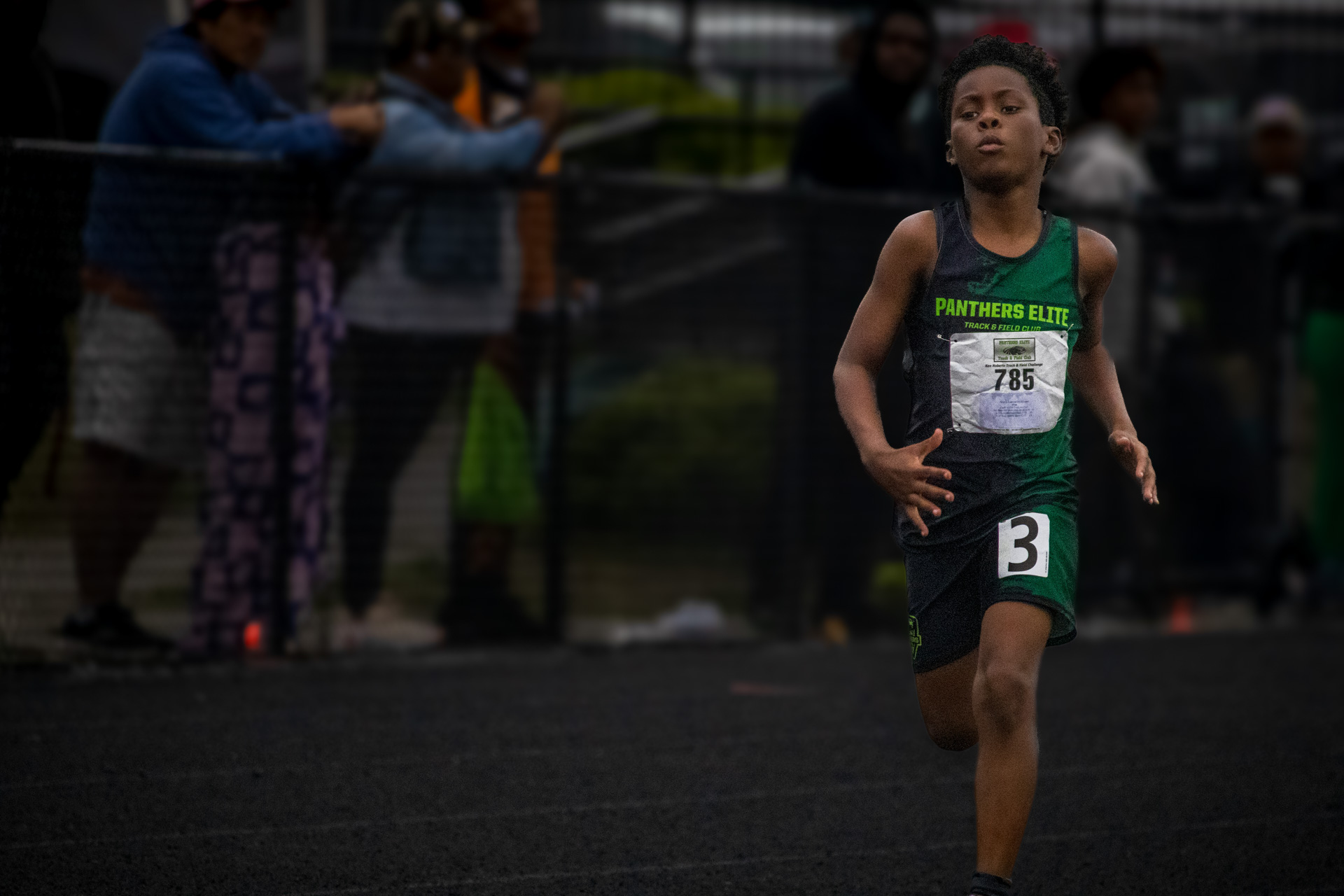 Young athlete running on track during a Panthers Elite meet.