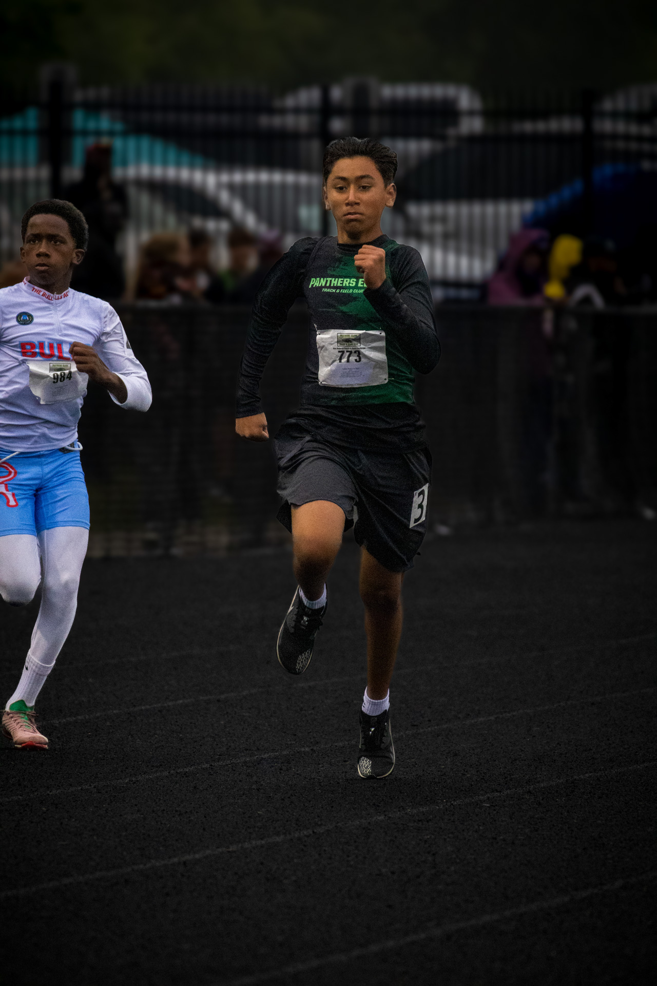 Young male athlete running on track during a race at Panthers Elite Track & Field event.