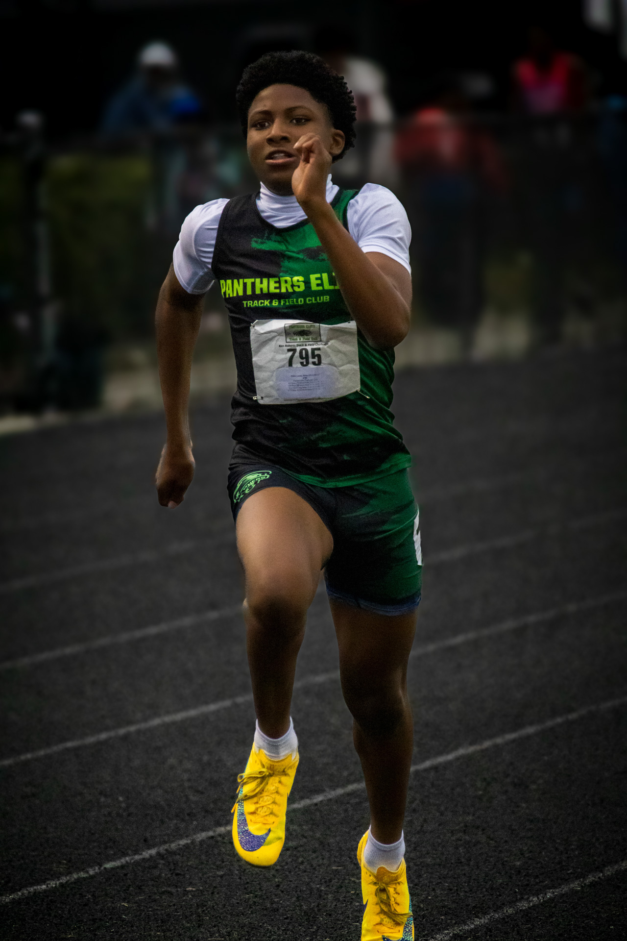 Young athlete running on track during a Panthers Elite meet.