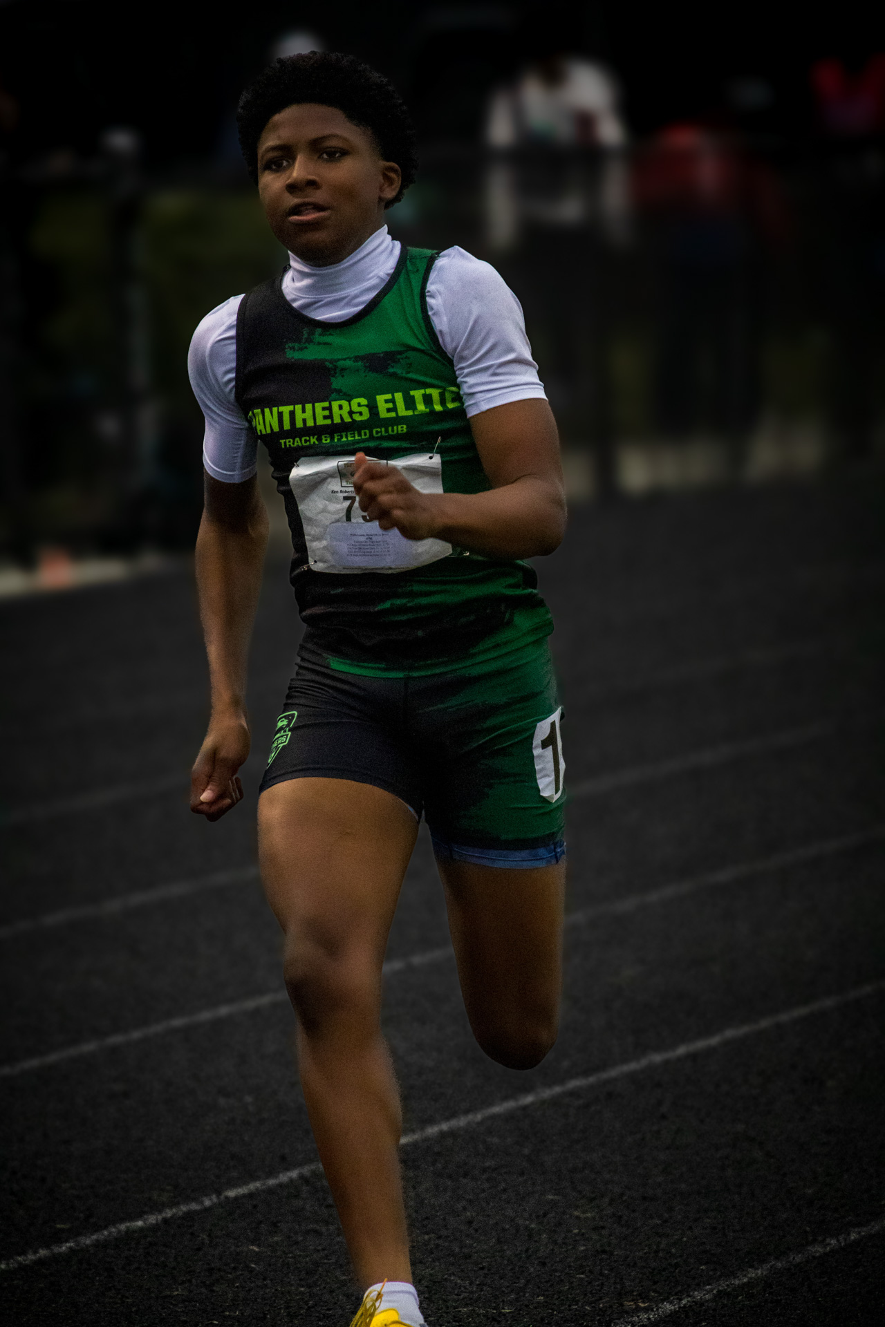 Young female athlete running on track during a Panthers Elite meet.