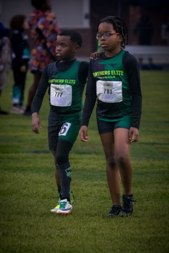 Two young Panthers Elite athletes walking on the track during a meet.