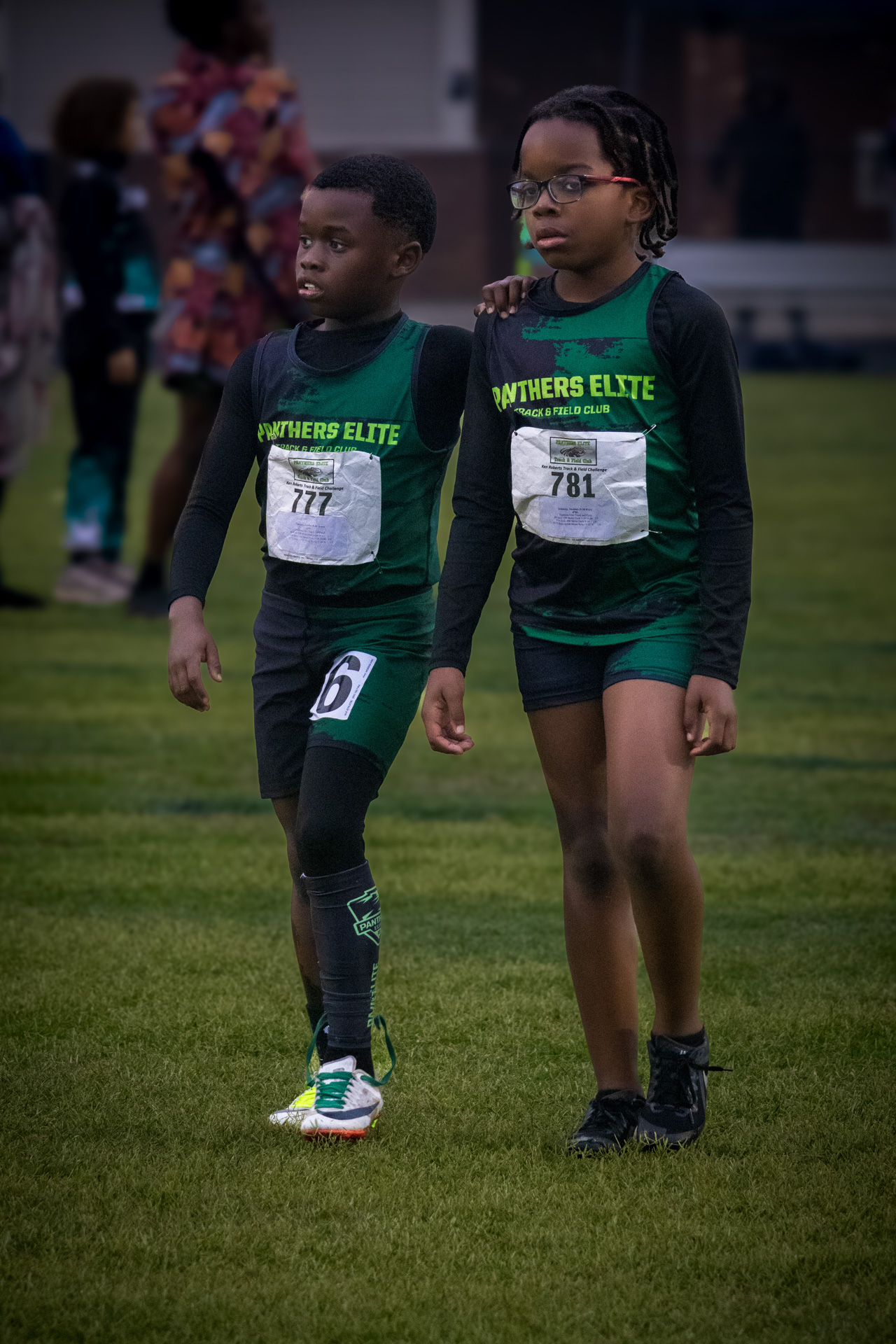 Two young Panthers Elite athletes walking on the track during a meet.