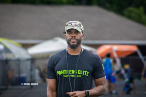 Portrait of a Panthers Elite Track & Field coach outdoors at a track event.