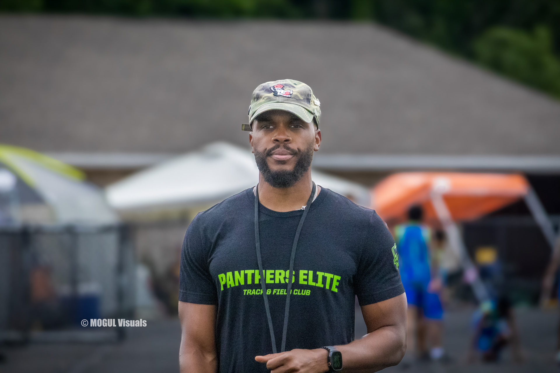 Portrait of a Panthers Elite Track & Field coach outdoors at a track event.
