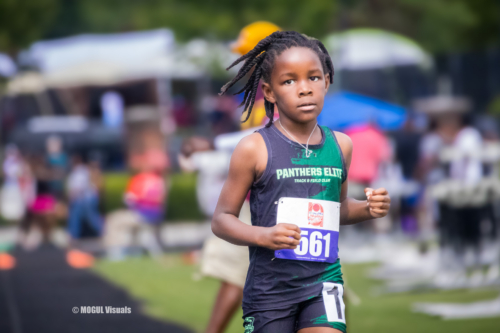 Young female athlete competing in a track race at a Panthers Elite event.