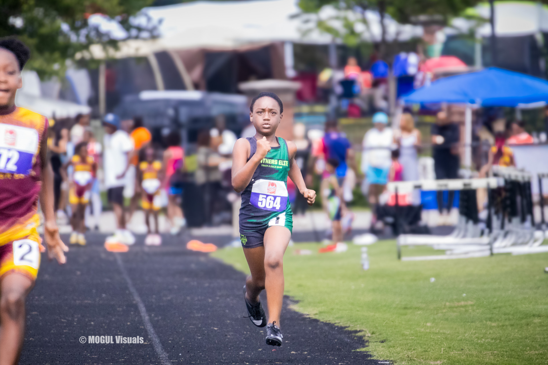 Young athlete running on track during a track and field meet.