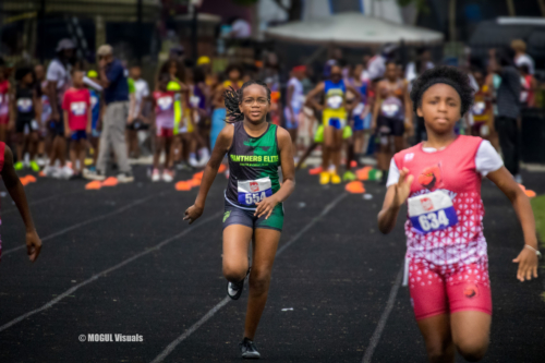 Young female athlete running on track at Panthers Elite Track & Field event.