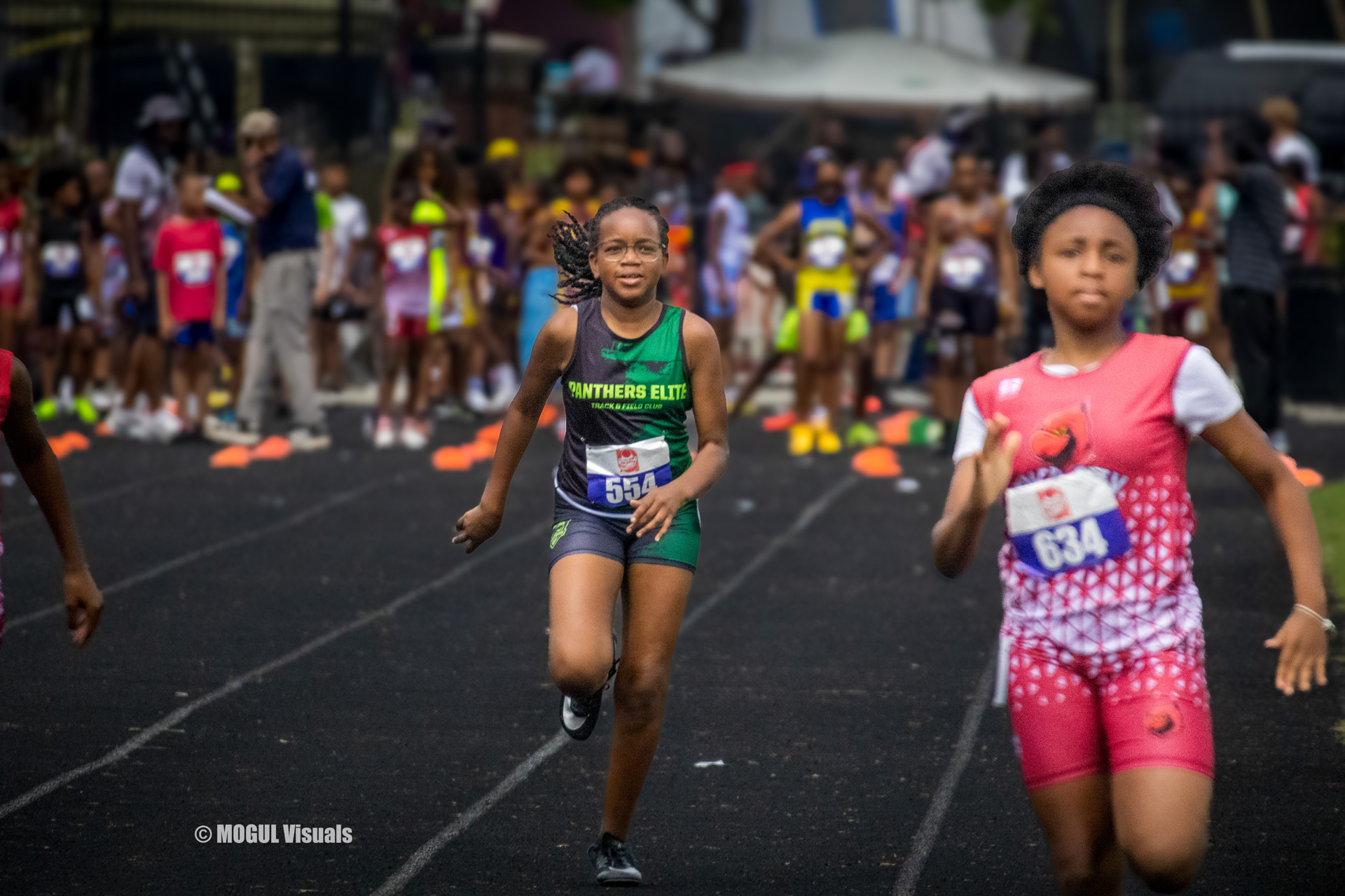 Young female athlete running on track at Panthers Elite Track & Field event.