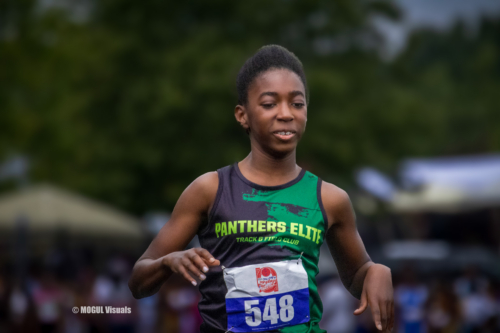Young female athlete running in a track race wearing Panthers Elite uniform and bib number 548.
