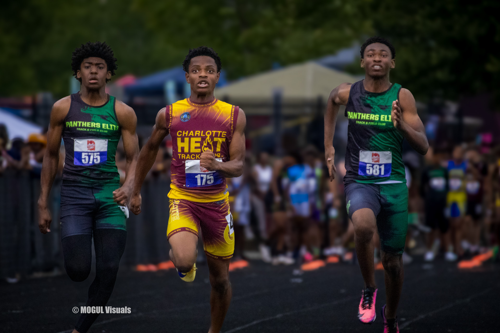 Three young male athletes competing in a track race at Panthers Elite Track & Field Club.