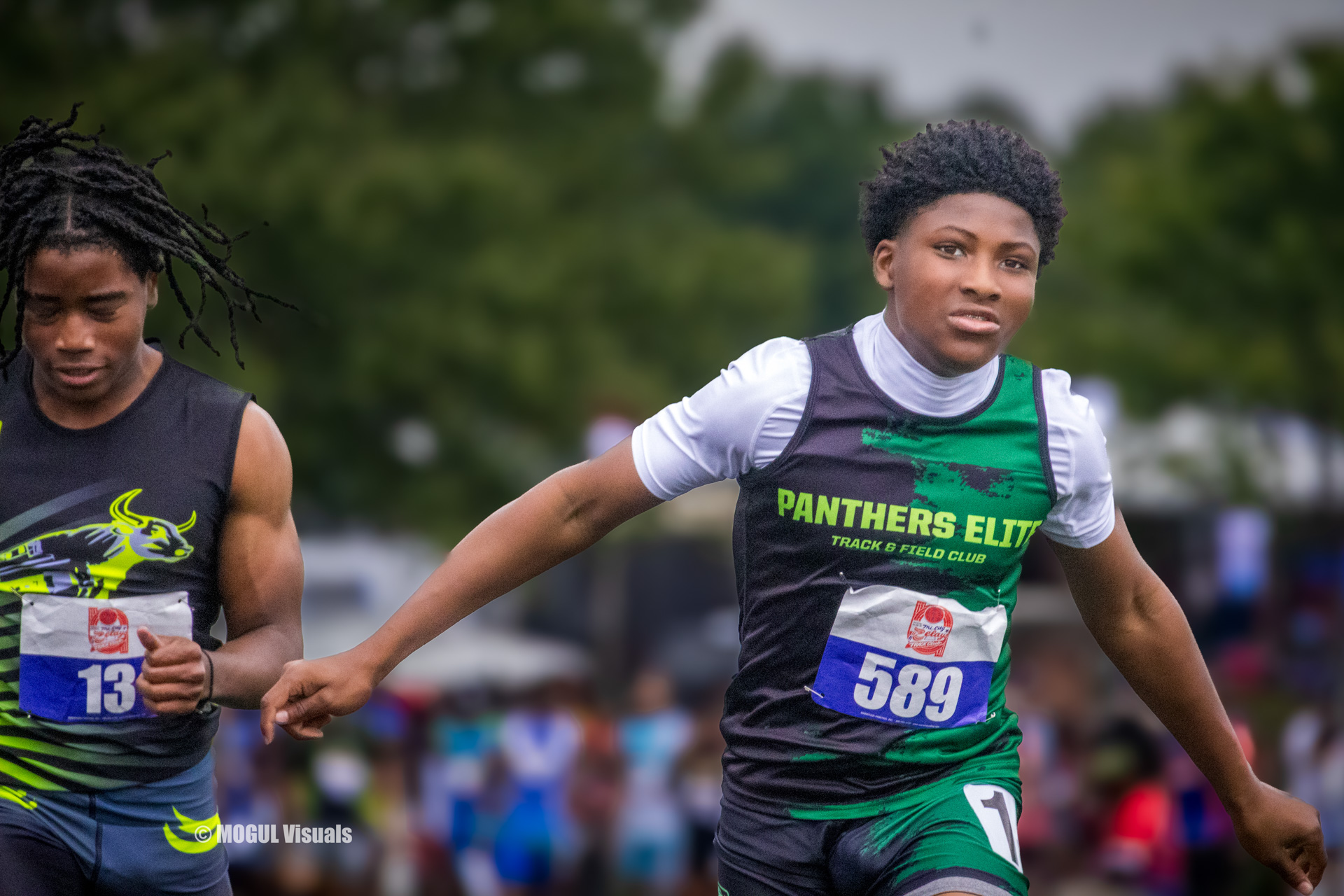 Young athlete running in a track race wearing Panthers Elite gear.
