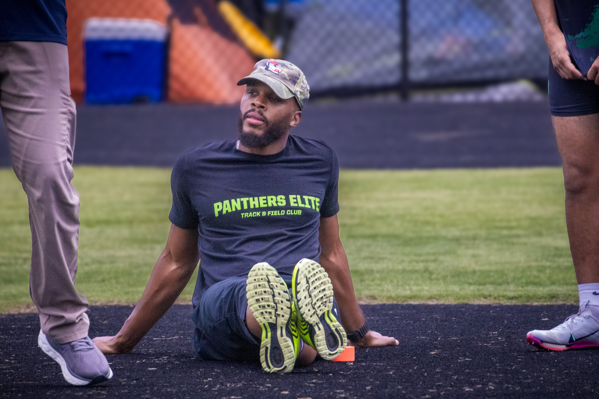 Male athlete sitting on the track during a Panthers Elite Track & Field practice session.