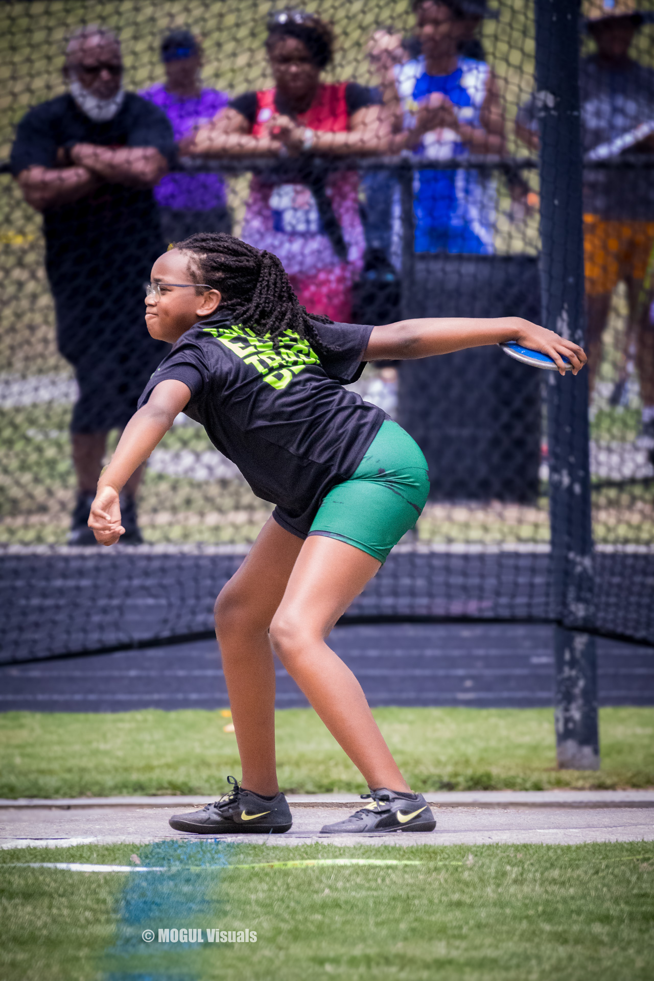 Athlete preparing to throw a discus during a track meet.