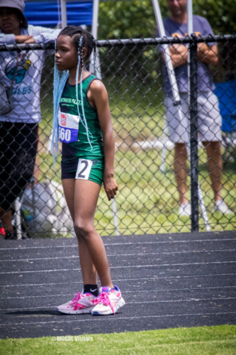 Athlete preparing for a race at the track meet, wearing a green uniform with the number 160 and pink.