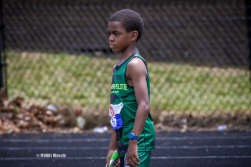 Young male athlete in green Panthers Elite uniform preparing for a race.