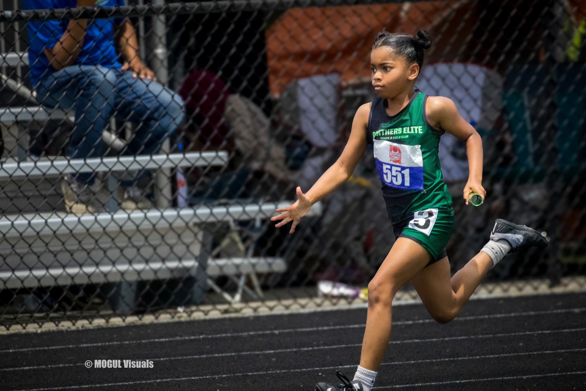 Young female athlete sprinting on the track during a meet.