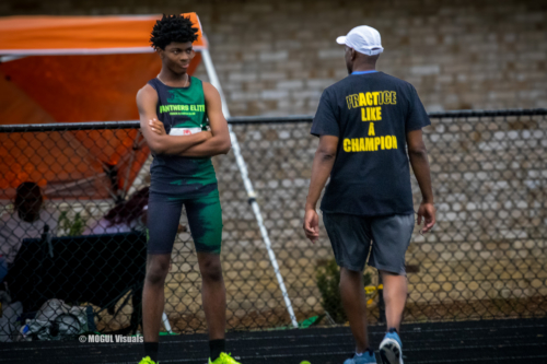 Panthers Elite athlete and coach discussing training strategies on the track.