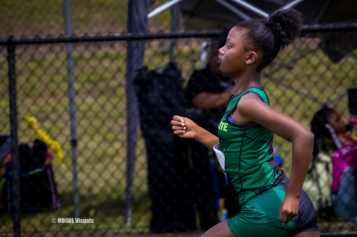 Young female athlete running on a track during a Panthers Elite Track & Field event.