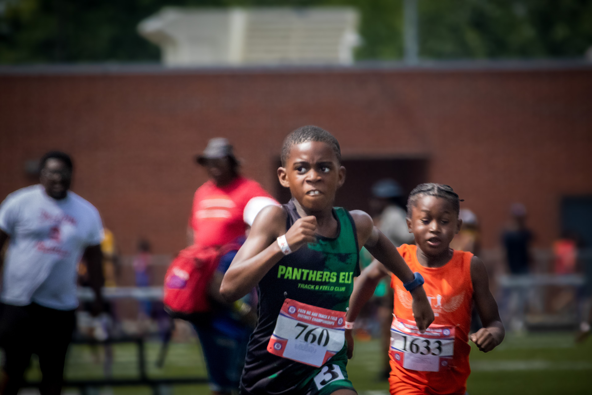 Young athletes competing in track and field at district qualifier event.