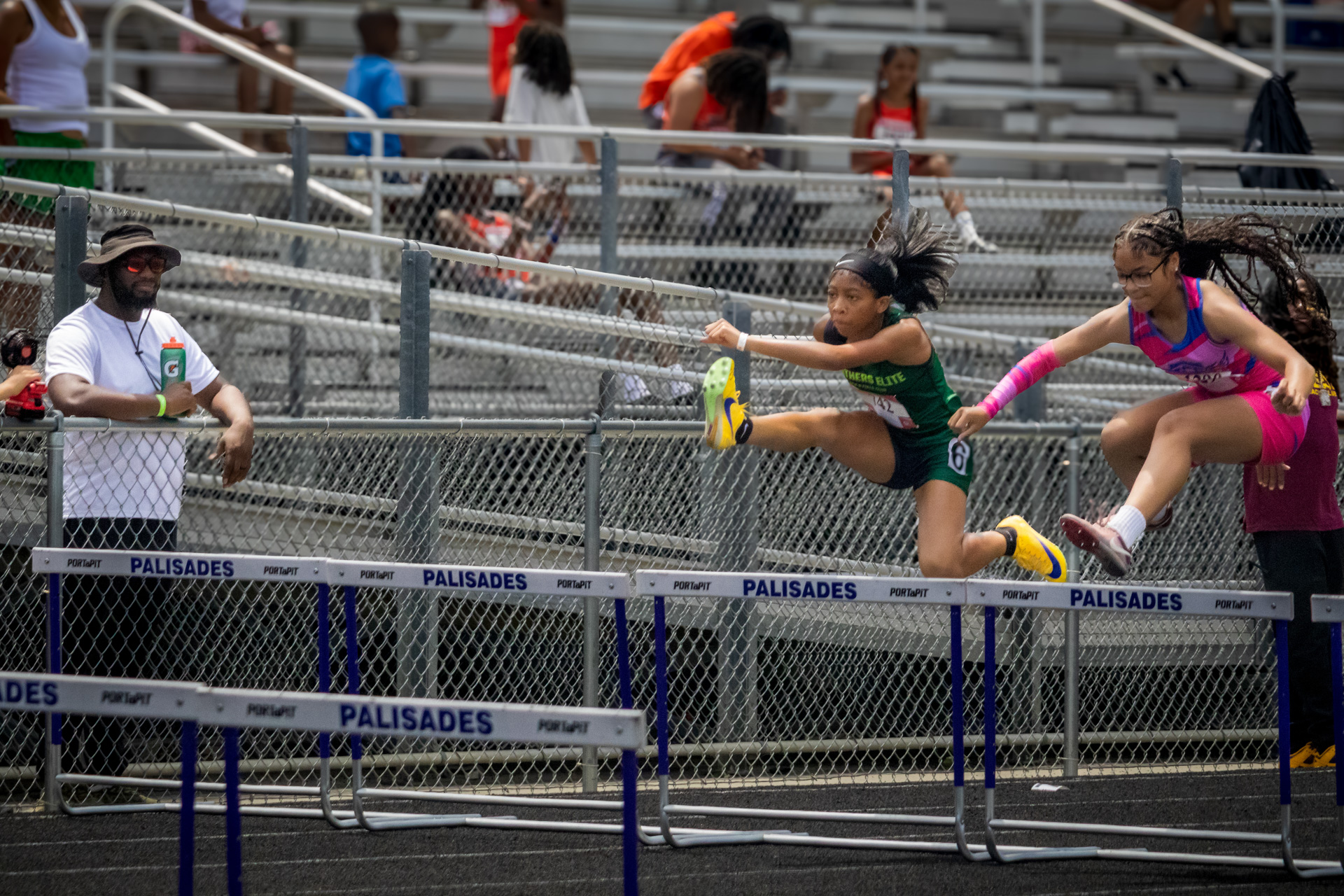 Young female athletes competing in hurdles at District Qualifier 2026.