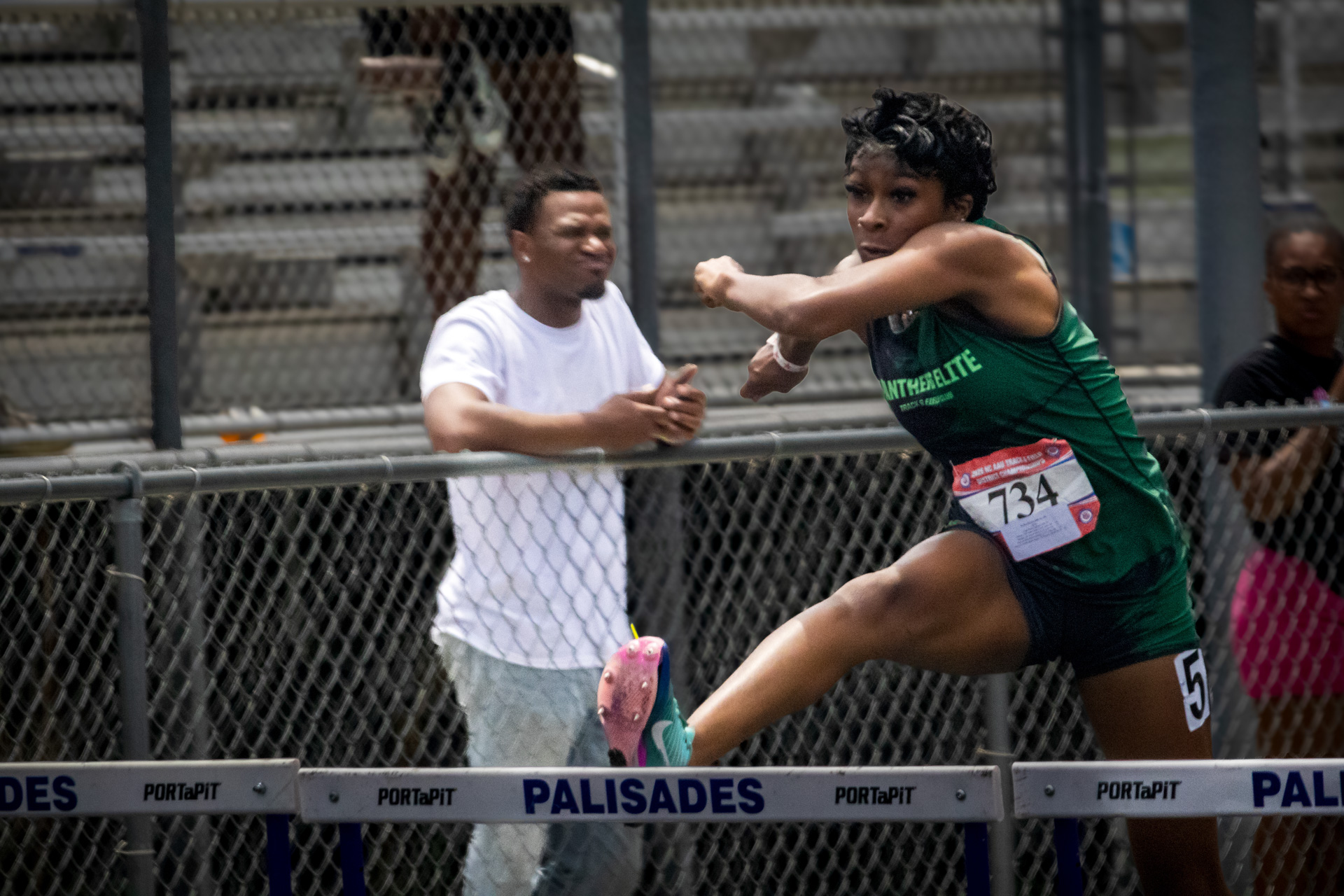 Female track athlete clearing hurdle at District Qualifier 2026.