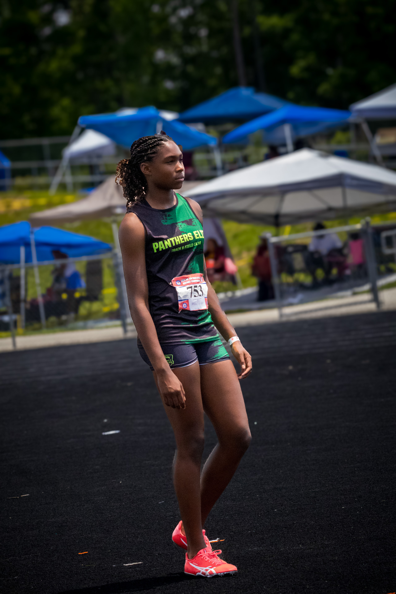 Young female athlete in Panthers Elite uniform at district track meet.