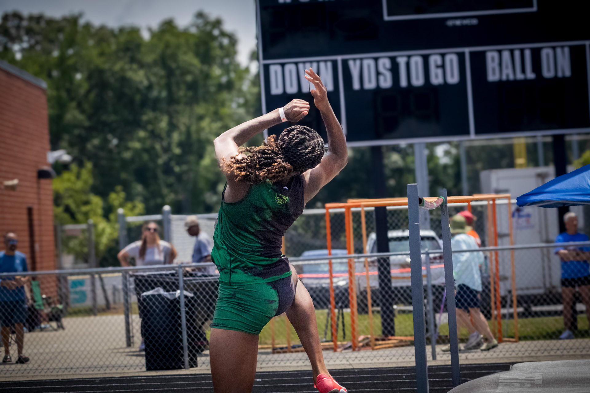 Female athlete jumping during a track and field event at district qualifier.