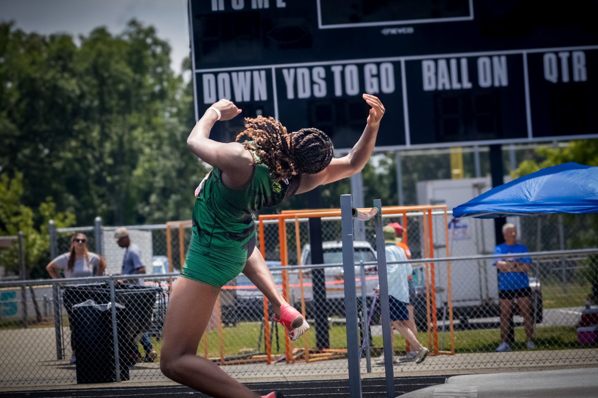 Female track athlete celebrating after a successful jump at the district qualifier meet.