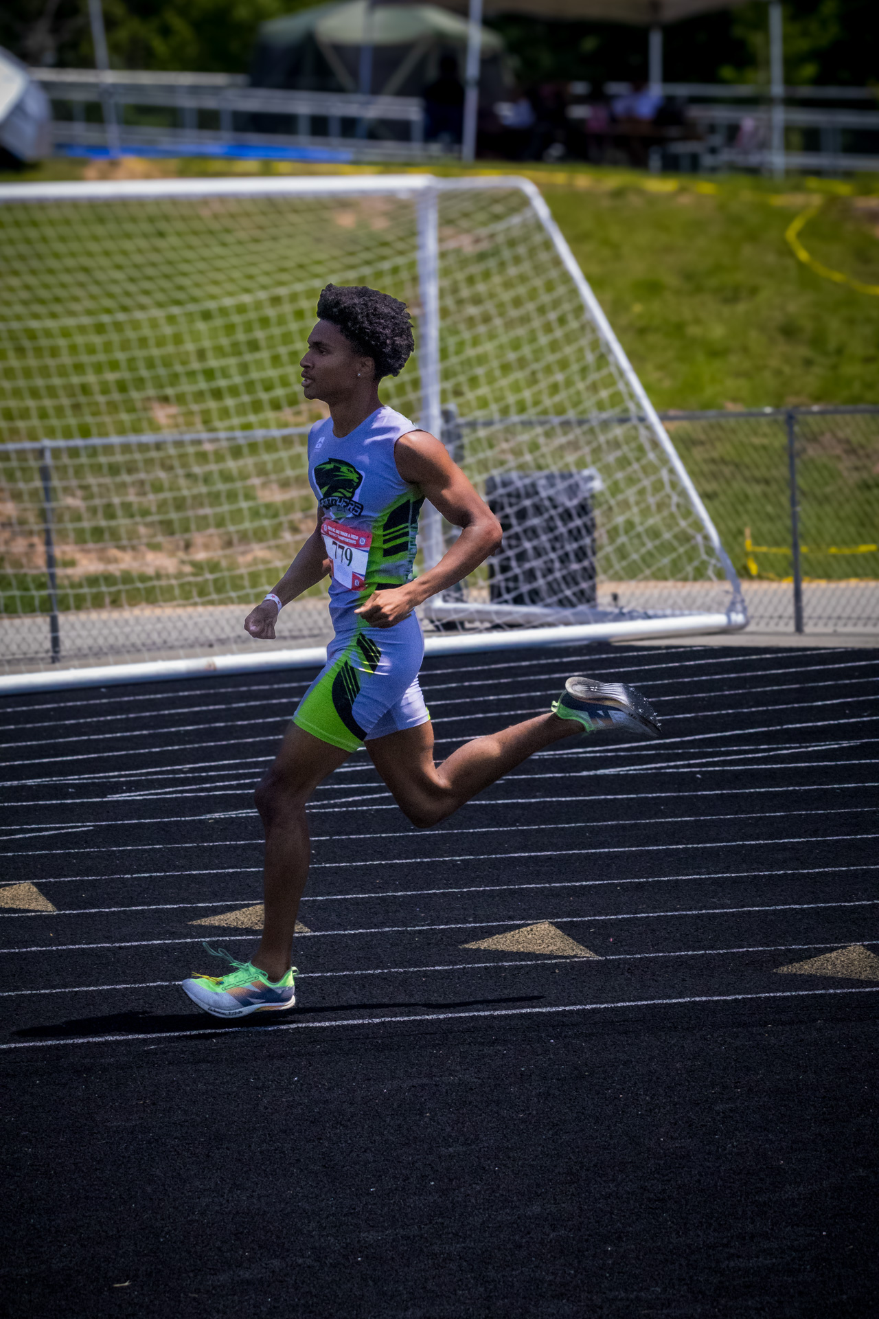 Young male athlete running on track at District Qualifier 2026.