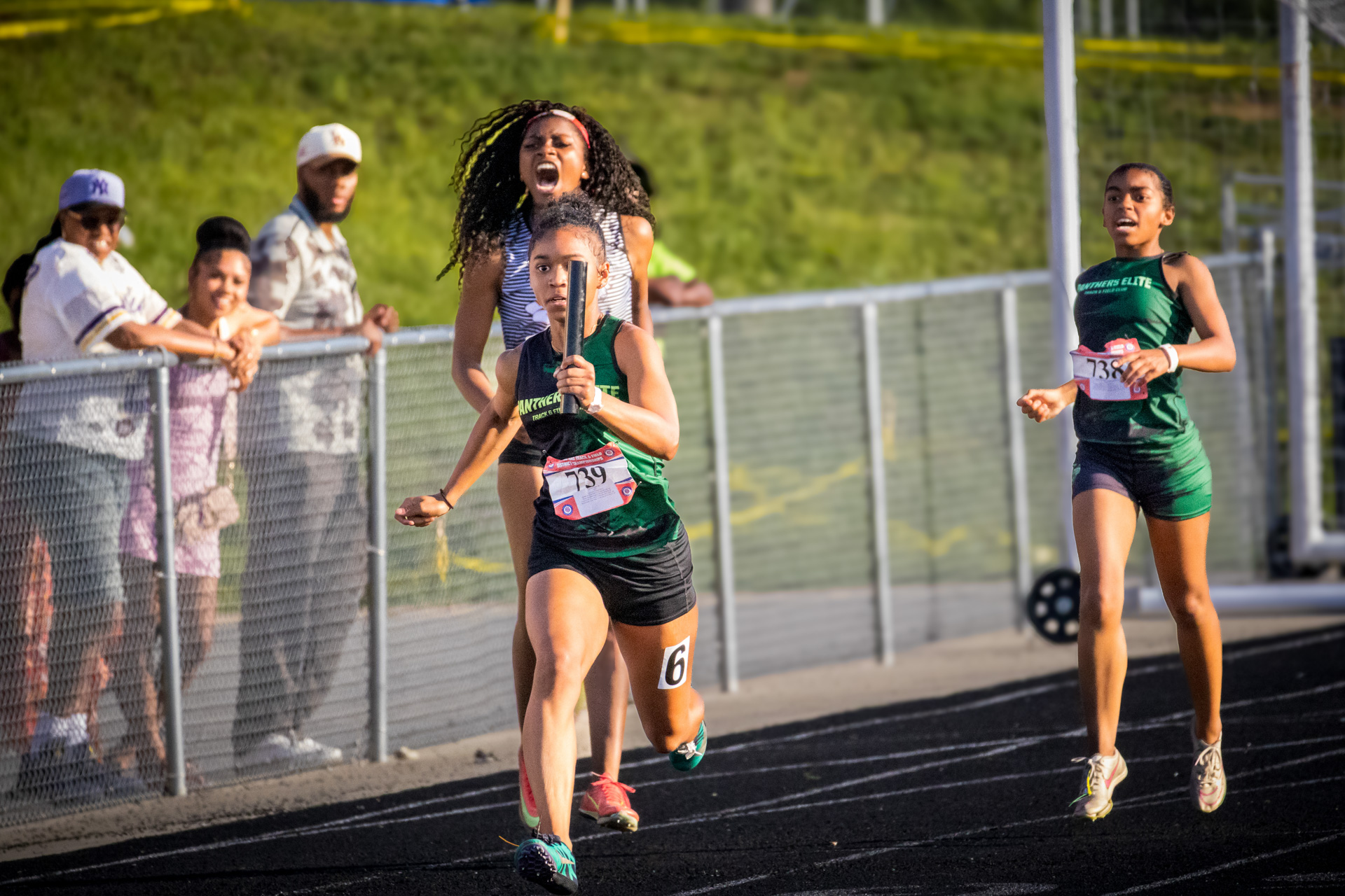 Young female sprinter winning a race at the District Qualifier 2026.