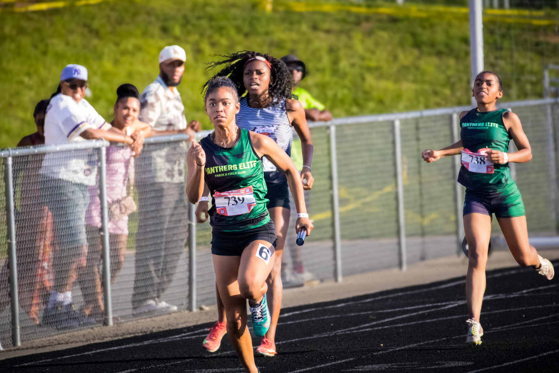 Young female athletes competing in a track race at the District Qualifier 2026.