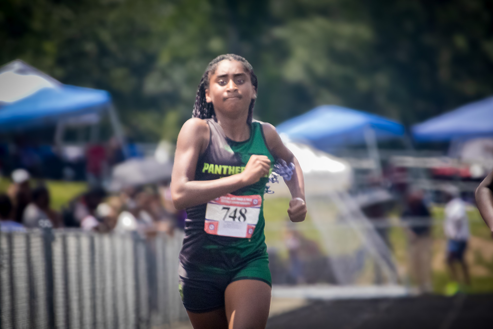 Female track athlete competing at District Qualifier 2026 event.