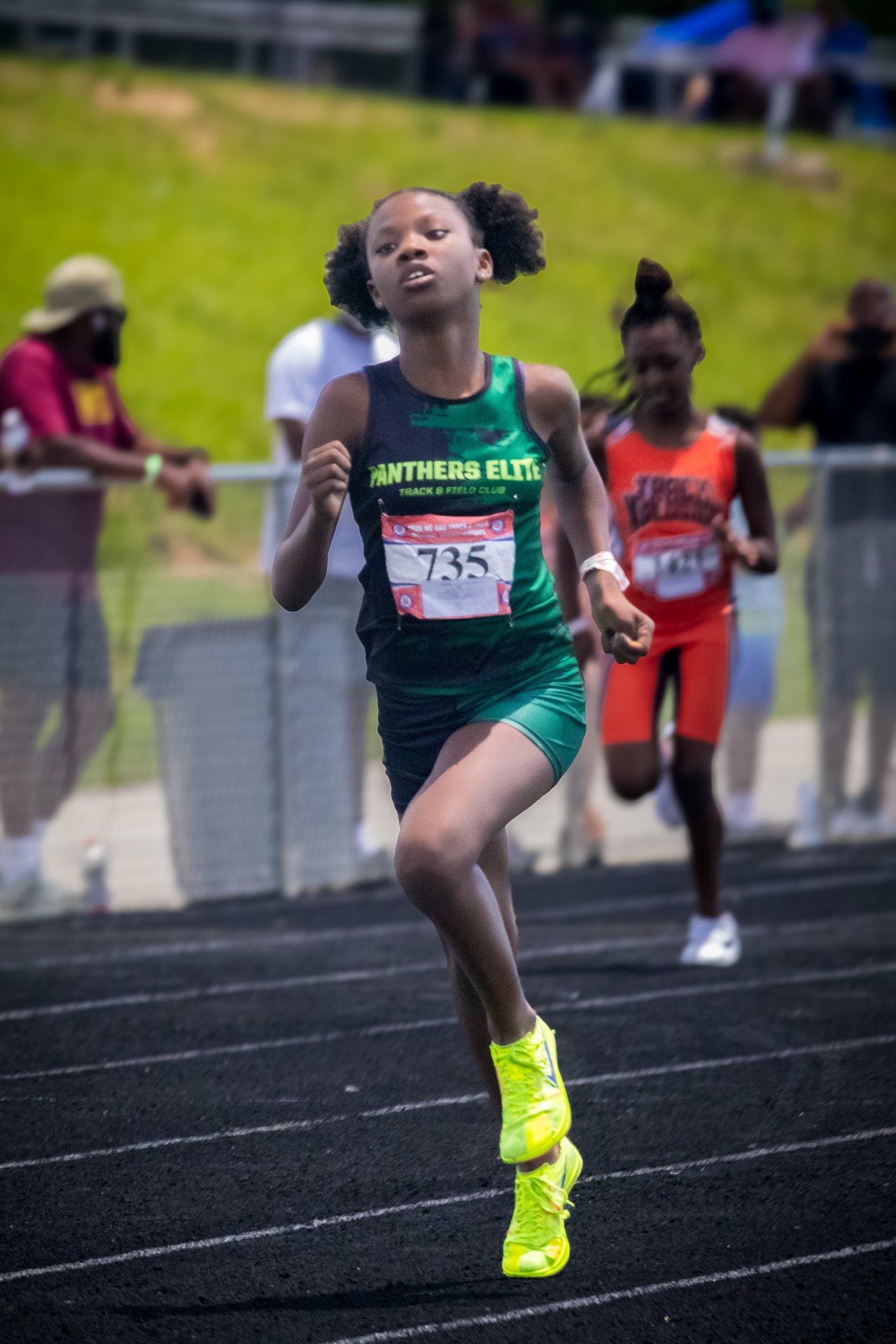 Young female athlete running on track during district qualifier event.