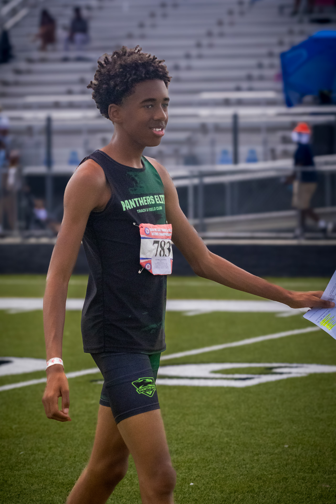 Young athlete smiling at District Qualifier 2026 event on track.