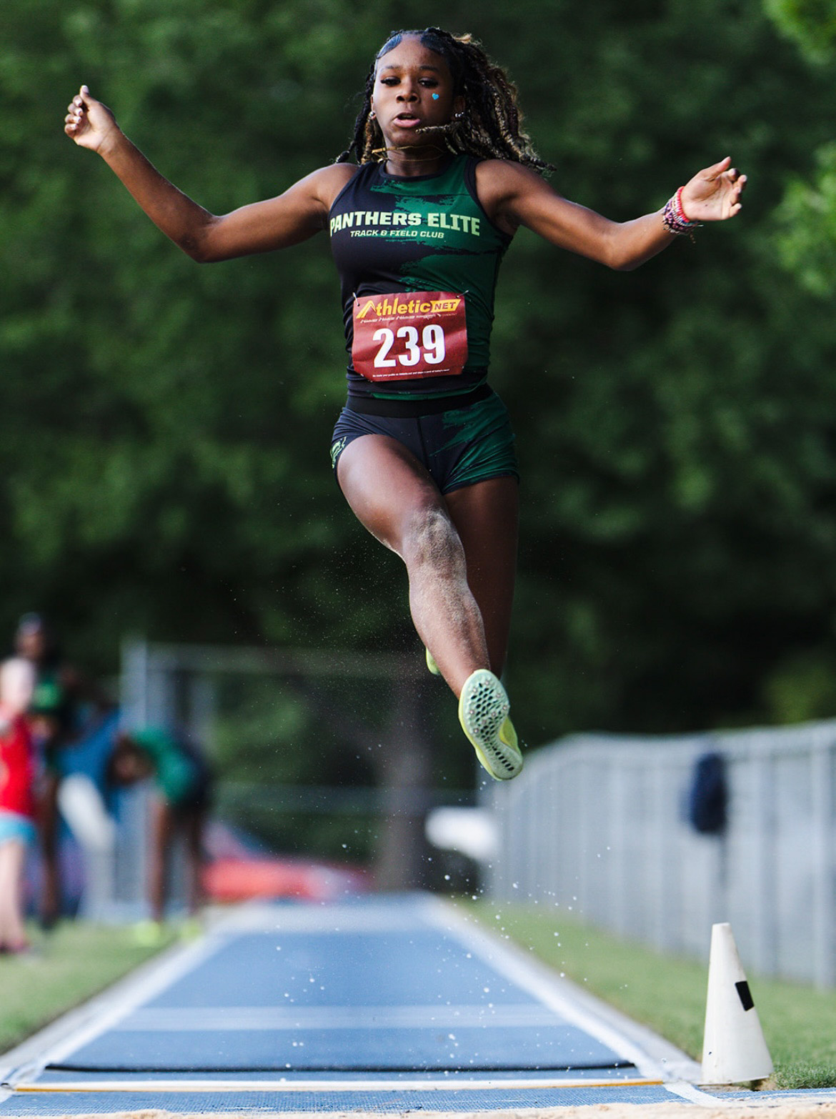 Young female athlete jumping during a track and field event.