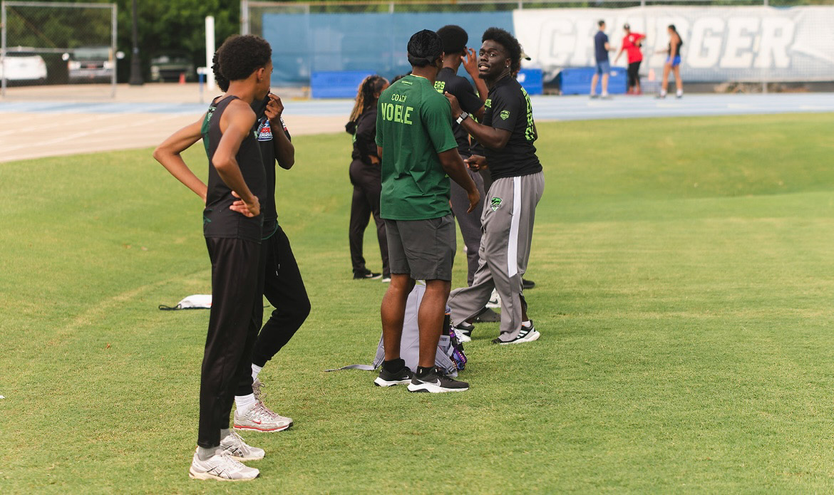Panthers Elite athletes preparing and discussing during a track meet.