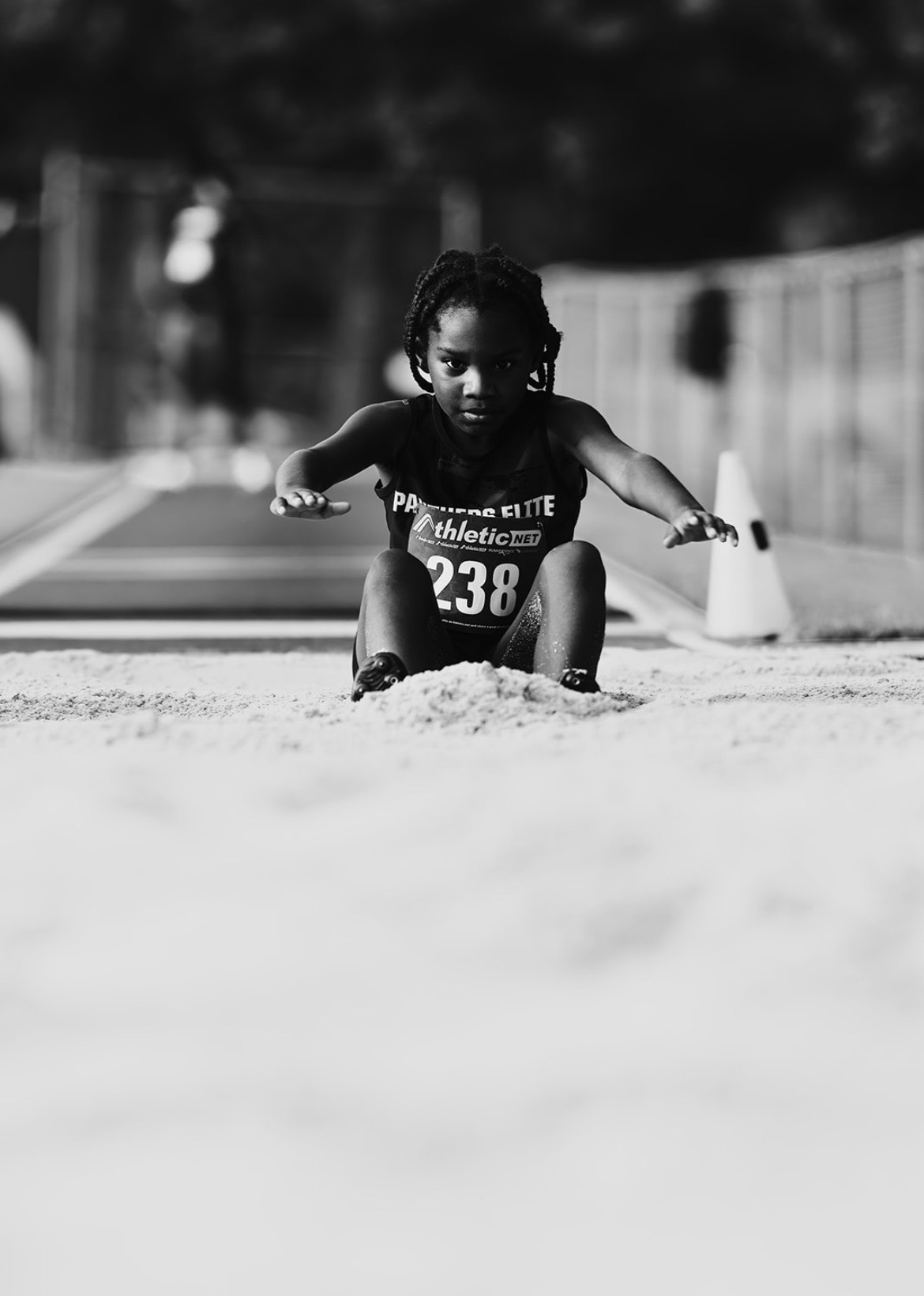 Young girl in athletic gear crawling on the track during a race.