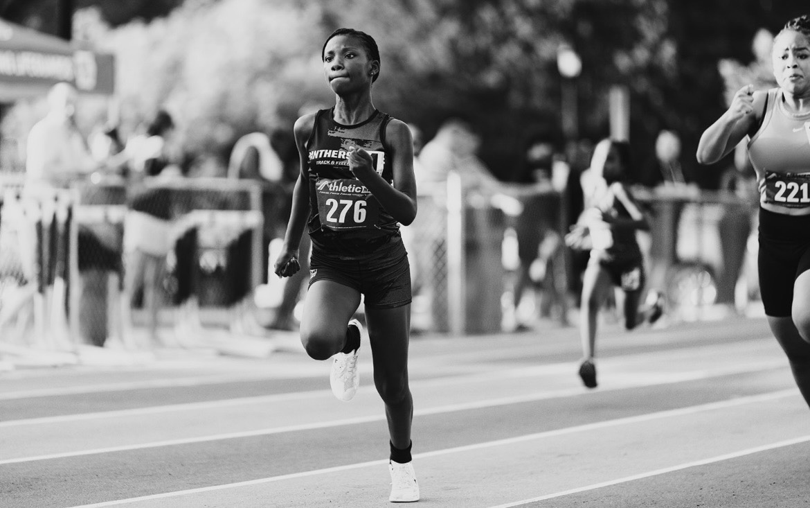 Young female runner competing in a track race at The Victory Lap 2026.