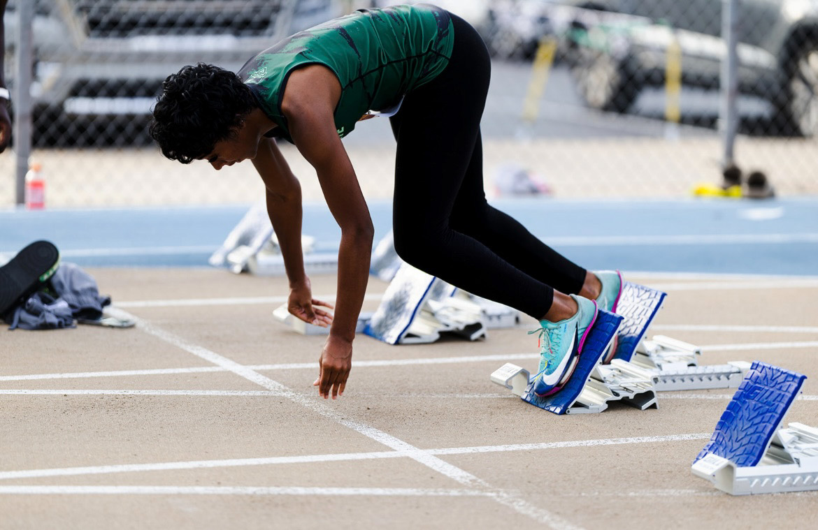 Panthers Elite athlete at starting block preparing for race.