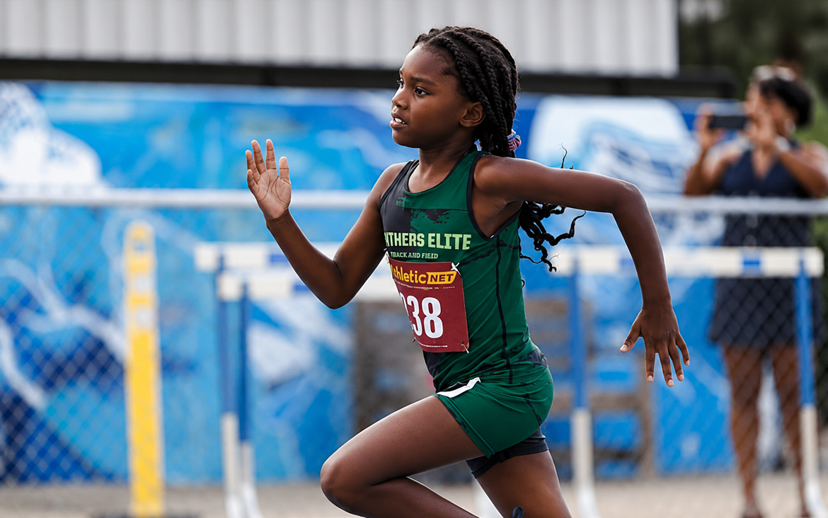 Young female athlete running in a track and field event at The Victory Lap 2026.